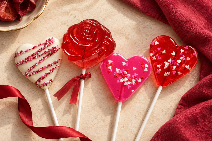 Valentine heart and rose lollipops on warm cream with cranberry ribbon